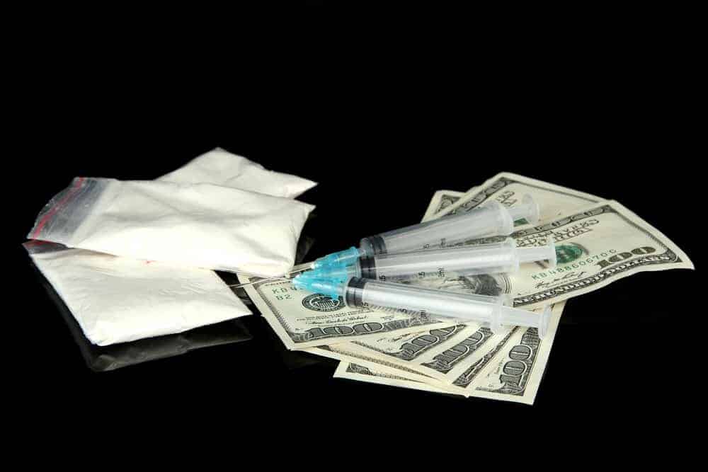 Drugs, money and syringes, isolated on black