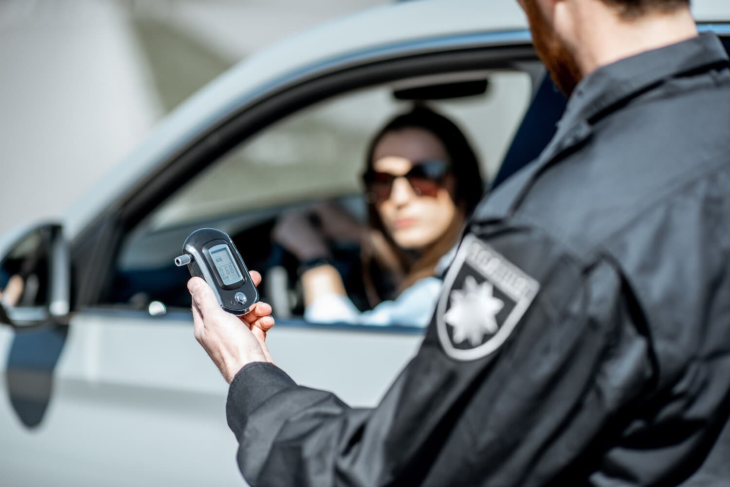 Police officer administering a breathalyzer test on driver under suspicion of alcohol consumption